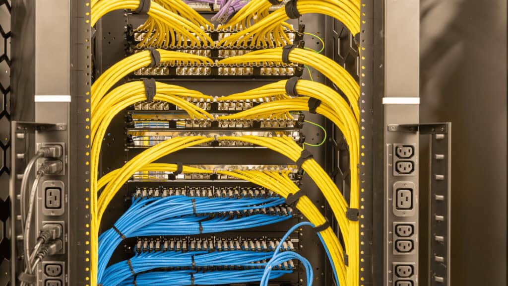 Network server rack with yellow and blue cables at Dynamix Tech.